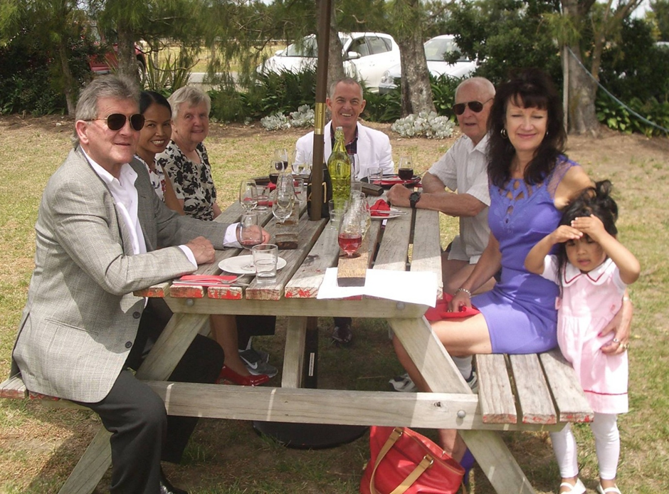 Wine is most often consumed in social settings with food like this small outdoor birthday celebration.